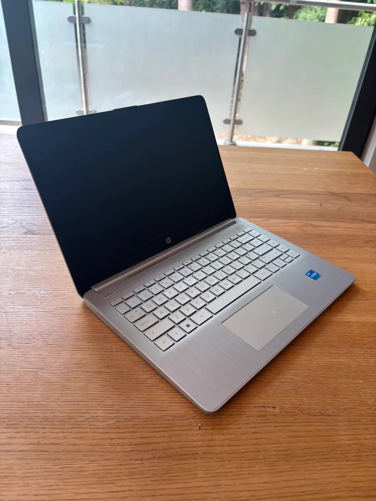 This image shows the side view of the HP. The HP has black screen housing, light grey keyboard, light grey case and a light grey touchpad which is slightly bigger then the Acer and Lenovo's. 