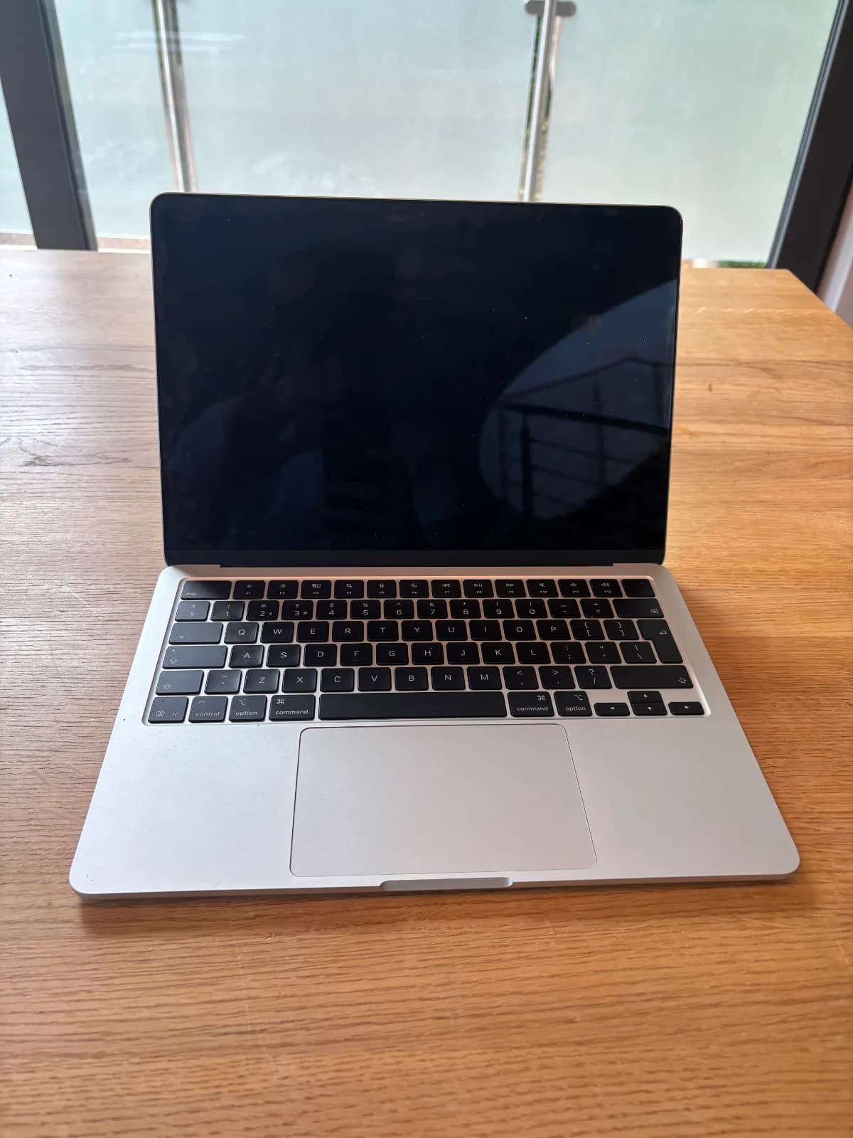 This image shows the front view of the Mac. The Mac has very thin screen casing, a black keyboard, light grey case and the largest touchpad of all the images. 